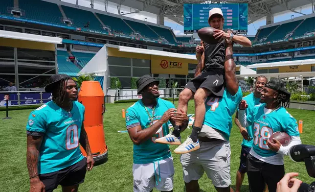 Mercedes driver Andrea Kimi Antonelli, of Italy, is lifted in the air by Miami Dolphins NFL football players ahead of the Formula One Miami Grand Prix auto race, Thursday, April 30, 2026, in Miami Gardens, Fla. (AP Photo/Rebecca Blackwell)