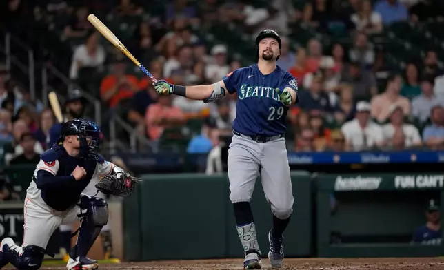 Seattle Mariners' Cal Raleigh (29) strikes out swinging as Houston Astros catcher Christian Vázquez kneels behind home plate during the third inning of a baseball game Tuesday, May 12, 2026, in Houston. (AP Photo/David J. Phillip)