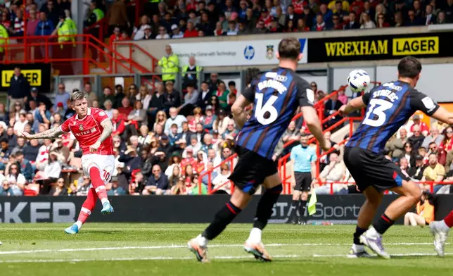 Wrexham's Josh Windass, left, scores their side's first goal of the game during the EFL Championship soccer match between Wrexham and Middlesbrough, in Wrexham, Wales, Saturday May 2, 2026. (Cody Froggatt/PA via AP)