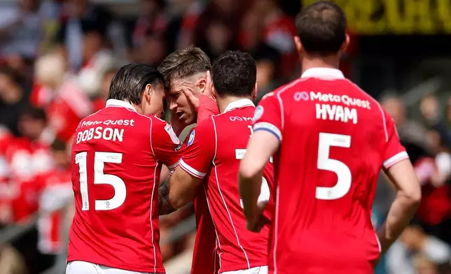 Wrexham's Josh Windass, second left, celebrates scoring his side's first goal of the game with teammates, during the EFL Championship soccer match between Wrexham and Middlesbrough, in Wrexham, Wales, Saturday May 2, 2026. (Cody Froggatt/PA via AP)