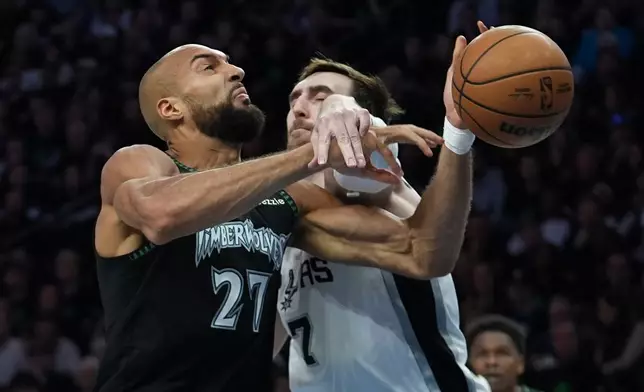 Minnesota Timberwolves center Rudy Gobert (27) is fouled as he drives to the basket against San Antonio Spurs center Luke Kornet (7) during the first half of Game 4 of an NBA basketball second-round playoffs series in Minneapolis, Sunday, May 10, 2026. (AP Photo/Abbie Parr)