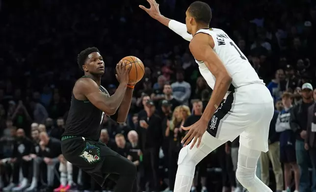 Minnesota Timberwolves guard Anthony Edwards, left, looks to shoot against San Antonio Spurs forward Victor Wembanyama (1) during the first half of Game 4 of an NBA basketball second-round playoffs series in Minneapolis, Sunday, May 10, 2026. (AP Photo/Abbie Parr)