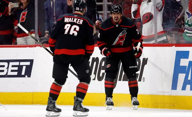 Carolina Hurricanes' Seth Jarvis, right, celebrates after his game-tying goal with teammate Sean Walker (26) during the third period of Game 2 of an NHL hockey Stanley Cup second-round playoff series against the Philadelphia Flyers in Raleigh, N.C., Monday, May 4, 2026. (AP Photo/Karl DeBlaker)