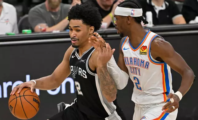 San Antonio Spurs guard Dylan Harper (2) drives against Oklahoma City Thunder guard Shai Gilgeous-Alexander (2) in the second half of Game 6 in the Western Conference finals NBA basketball playoffs series, Thursday, May 28, 2026, in San Antonio. (AP Photo/Darren Abate)