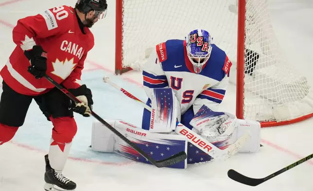 United States' goalkeeper Devin Cooley (1) defends the goal while pressured by Canada's Ryan O'Reilly (90) during the third period of the 2026 IIHF Men's Ice Hockey World Championship quarterfinal match between Canada and United States, in Fribourg, Switzerland, Thursday, May 28, 2026. (AP Photo/Darko Bandic)