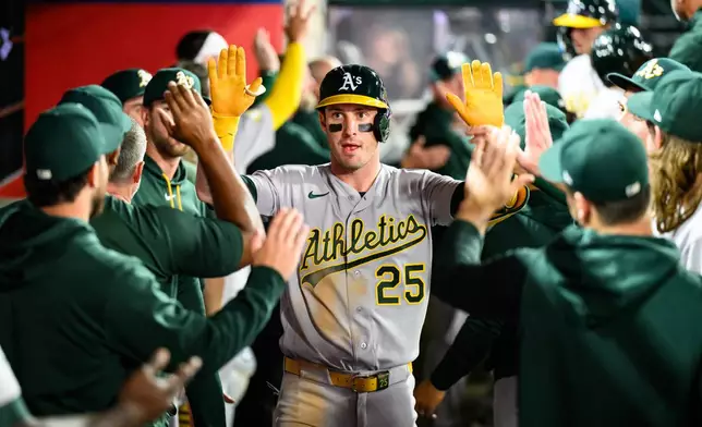 Athletics' Brent Rooker is greeted by teammates after hitting a home run during the eighth inning of a baseball game against the Los Angeles Angels, Tuesday, May 19, 2026, in Anaheim, Calif. (AP Photo/William Liang)