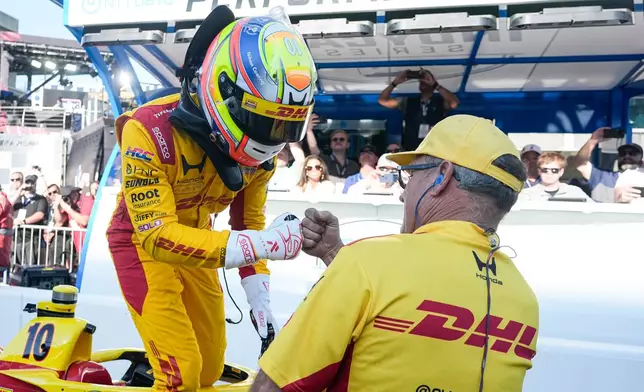 Alex Palou, of Spain, celebrates with a member of his crew during qualifications for the Indianapolis 500 auto race at the in Indianapolis, Sunday, May 17, 2026. (AP Photo/Michael Conroy)