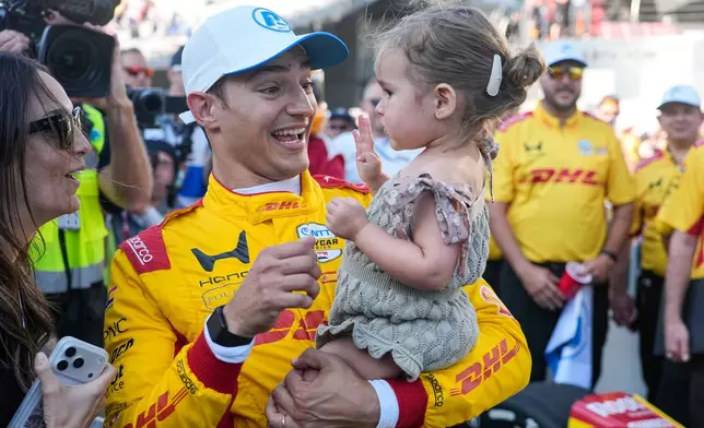 Alex Palou, second from left, of Spain, celebrates with his wife Esther Valle, left, and daughter Lucía after winning the pole during qualifications for the Indianapolis 500 auto race at the Indianapolis Motor Speedway in Indianapolis, Sunday, May 17, 2026. (AP Photo/Michael Conroy)