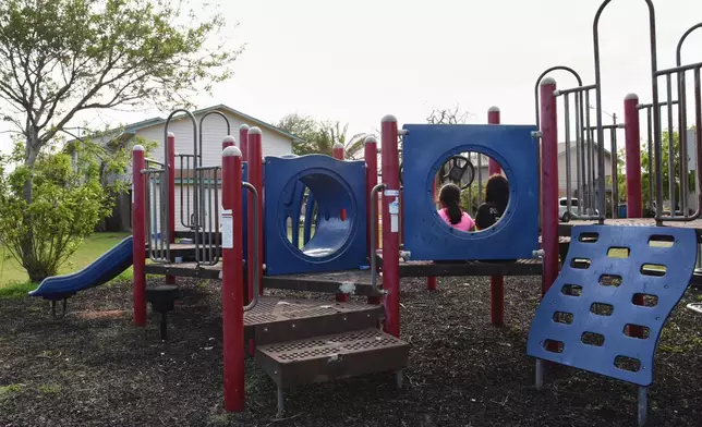 Two sisters play in a neighborhood playground that sits mostly vacant, April 13, 2026, after neighbors left their public housing homes in Port Isabel, Texas. (AP Photo/Valerie Gonzalez)