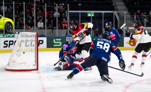Austria's Peter Schneider, 2nd from left, scores his side's fourth goal past Britain's goaltender Mat Robson, during the 2026 IIHF Men's Ice Hockey World Championship preliminary round group A game between Britain and Austria, in Zurich, Switzerland, Saturday, May 16, 2026. (Andreas Becker/Keystone via AP)