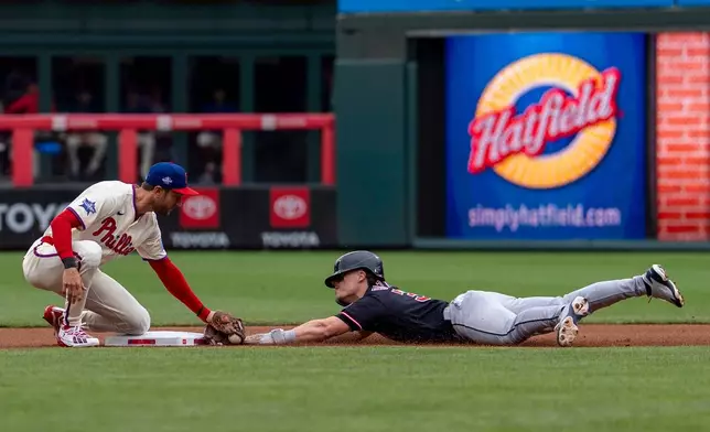 Philadelphia Phillies shortstop Trea Turner, left, tags Cleveland Guardians' Travis Bazzana, right, out as he tries to steal second base during the first inning of a baseball game, Sunday, May 24, 2026, in Philadelphia. (AP Photo/Chris Szagola)