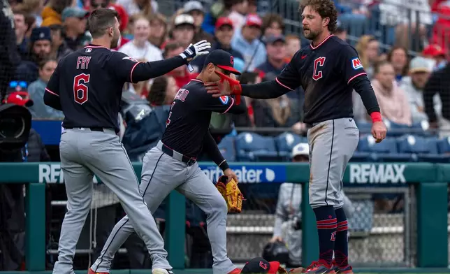 Cleveland Guardians' Rhys Hoskins, right, is congratulated by teammates David Fry, left, and Brayan Rocchio, center, after his RBI double during the sixth inning of a baseball game against the Philadelphia Phillies, Sunday, May 24, 2026, in Philadelphia. (AP Photo/Chris Szagola)