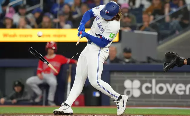 Toronto Blue Jays' Addison Barger breaks his bat while facing Los Angeles Angels pitcher Jack Kochanowicz during first-inning baseball game action in Toronto, Saturday, May 9, 2026. (Chris Young/The Canadian Press via AP)