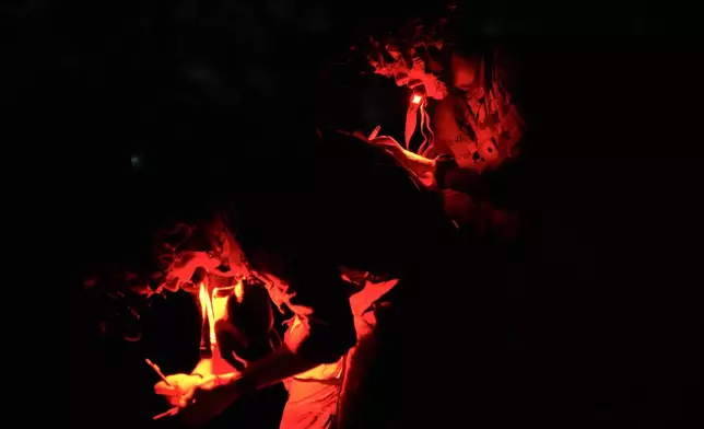 A cadet uses another cadet's back to plot points on a map before competing in night land navigation during the Sandhurst Military Skills Competition at the United States Military Academy in West Point, N.Y., Friday, May 1, 2026. (AP Photo/Julia Demaree Nikhinson)