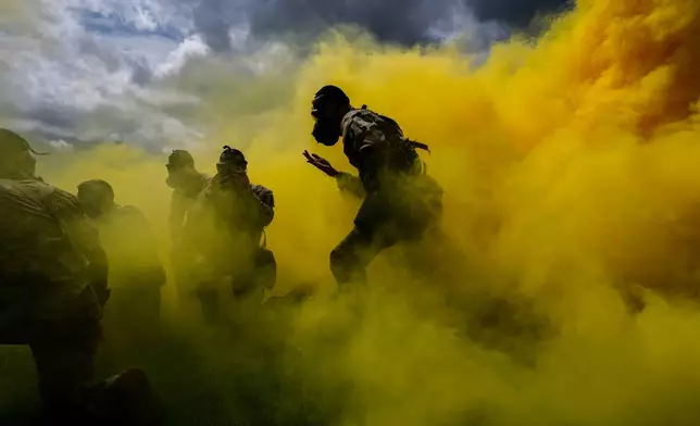 A West Point cadet dons a gas mask while running through smoke during the crucible portion of the Sandhurst Military Skills Competition at the United States Military Academy in West Point, N.Y., Saturday, May 2, 2026. (AP Photo/Julia Demaree Nikhinson)