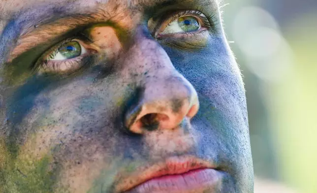 A cadet applies camouflage face paint before competing in the grenade assault course during the Sandhurst Military Skills Competition at the United States Military Academy in West Point, N.Y., Friday, May 1, 2026. (AP Photo/Julia Demaree Nikhinson)