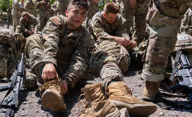 A University of Santa Barbara Army ROTC cadet laces up his boots after competing in the zodiac boat portion of the Sandhurst Military Skills Competition at the United States Military Academy in West Point, N.Y., Friday, May 1, 2026. (AP Photo/Julia Demaree Nikhinson)