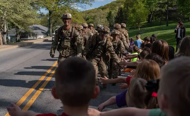 Cadets high five kids while competing in a timed eight mile ruck during the Sandhurst Military Skills Competition at the United States Military Academy in West Point, N.Y., Friday, May 1, 2026. (AP Photo/Julia Demaree Nikhinson)
