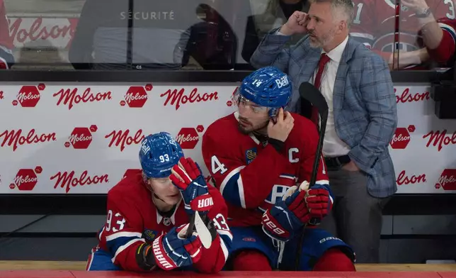 Montreal Canadiens' Ivan Demidov (93), Nick Suzuki (14) and head coach Martin St. Louis, right, watch the final minutes of play against the Buffalo Sabres in Game 6 of a second-round NHL hockey Stanley Cup playoff series in Montreal, Saturday, May 16, 2026. (Christinne Muschi/The Canadian Press via AP)