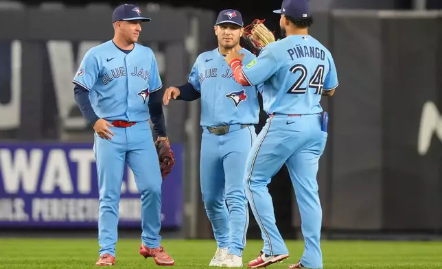 Toronto Blue Jays left fielder Yohendrick Piñango, right, center fielder Daulton Varsho, center, and right fielder Myles Straw celebrate after winning a baseball game against the New York Yankees, Wednesday, May 20, 2026, in New York. (AP Photo/Yuki Iwamura)