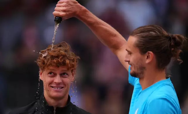 Alexander Zverev, of Germany, right, pours sparkling wine over the head of Jannik Sinner, of Italy, at the end of the men's singles tennis final match against at the Madrid Open tennis tournament in Madrid, Spain, Sunday, May 3, 2026. (AP Photo/Manu Fernandez)