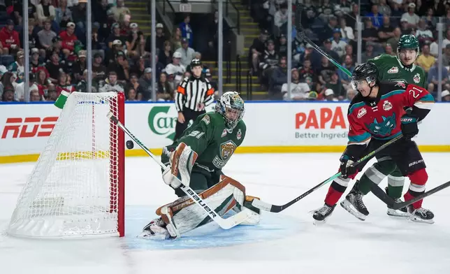 Everett Silvertips goalie Anders Miller (31) makes a save as Kelowna Rockets' Owen Folstrom (21) and Everett's Brek Liske (42) watch during the second period of a Memorial Cup hockey game, in Kelowna, B.C., on Wednesday, May 27, 2026. (Darryl Dyck/The Canadian Press via AP)