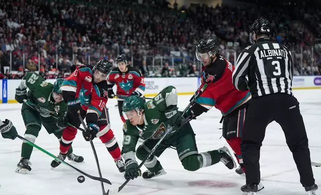 Kelowna Rockets' Tij Iginla (11) and Tomas Poletin (10) vie for the puck against Everett Silvertips' Zackary Shantz (19) and Jesse Heslop (22) during the second period of a Memorial Cup hockey game, in Kelowna, B.C., on Wednesday, May 27, 2026. (Darryl Dyck/The Canadian Press via AP)
