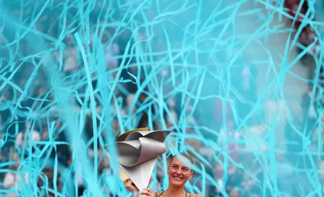 Marta Kostyuk of Ukraine celebrates with the trophy after winning the final match at the Madrid Open tennis tournament in Madrid, Spain, Saturday, May 2, 2026. (AP Photo/Manu Fernandez)