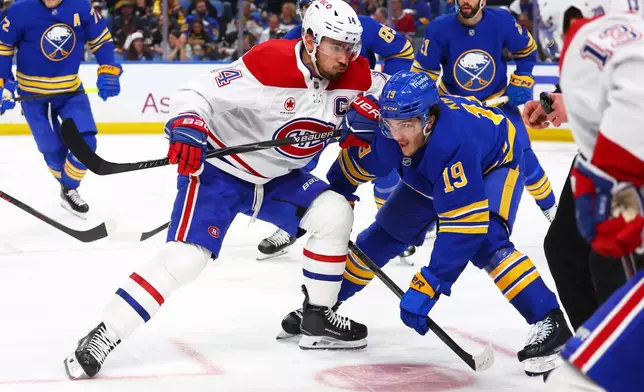 Montreal Canadiens center Nick Suzuki, front left, and Buffalo Sabres center Peyton Krebs (19) battle after a face-off during the second period in Game 1 of a second-round NHL hockey Stanley Cup playoff series, Wednesday, May 6, 2026, in Buffalo, N.Y. (AP Photo/Jeffrey T. Barnes)