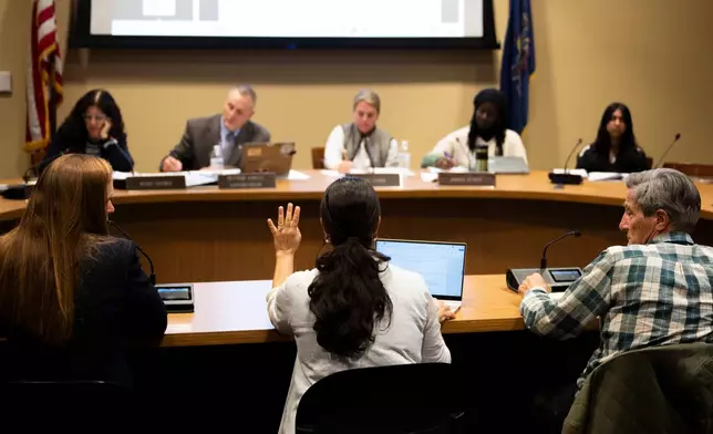 Members of the Lower Merion Board of School Directors speak with attendees at a school board meeting on Monday, May 11, 2026, in Ardmore, Pa. (AP Photo/Joe Lamberti)