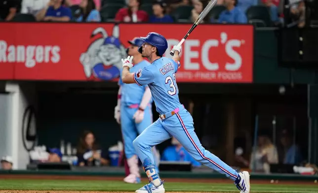 Texas Rangers' Evan Carter follows through on a two-run home run in the eighth inning of a baseball game against the Chicago Cubs Sunday May 10, 2026, in Arlington, Texas. (AP Photo/Tony Gutierrez)