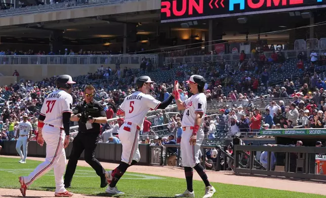 Minnesota Twins' Ryan Kreidler (5) celebrates with Tristan Gray (4) after hitting a three-run home run during the fourth inning of a baseball game against the Houston Astros, Wednesday, May 20, 2026, in Minneapolis. (AP Photo/Abbie Parr)