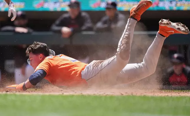 Houston Astros' Zach Dezenzo scores off an RBI-single hit by Christian Vázquez (2) during the second inning of a baseball game against the Minnesota Twins, Wednesday, May 20, 2026, in Minneapolis. (AP Photo/Abbie Parr)