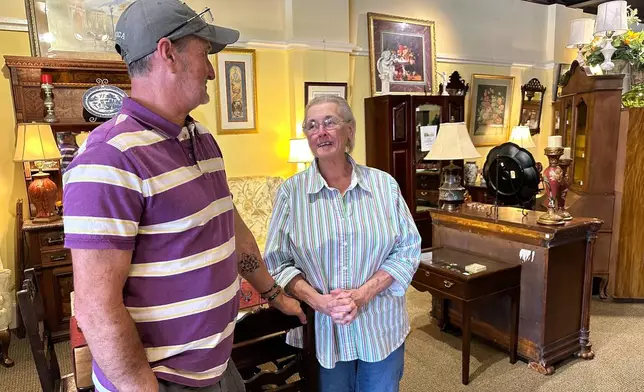 Michael Aycock, 56, left, and his mother Phyllis Aycock, 79, discuss economic conditions as they stand on the showroom floor of their antiques shop in downtown Nashville, N.C., March 11, 2026. (AP Photo/Bill Barrow)
