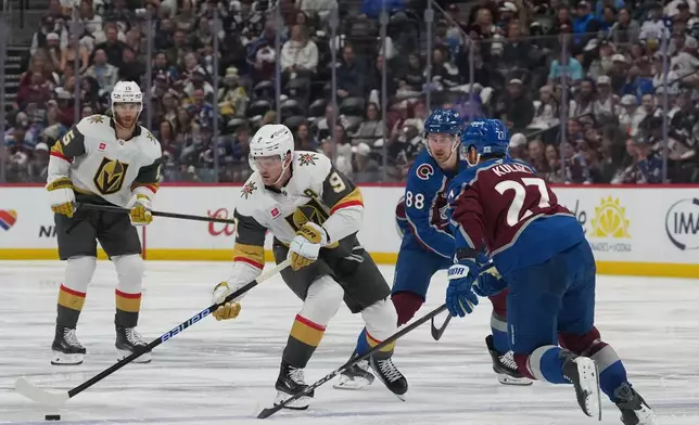Vegas Golden Knights center Jack Eichel (9) drives with the puck as Colorado Avalanche defenseman Brett Kulak (27) and center Martin Necas (88) defend while Golden Knights defenseman Noah Hanifin (15) trails the play during the second period in Game 2 of the Western Conference finals NHL hockey Stanley Cup playoff series Friday, May 22, 2026, in Denver. (AP Photo/David Zalubowski)