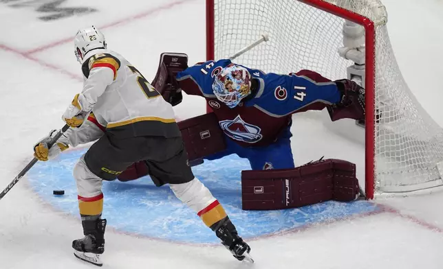 Vegas Golden Knights center Nic Dowd, left, puts a shot on Colorado Avalanche goaltender Scott Wedgewood during the first period in Game 2 of the Western Conference finals NHL hockey Stanley Cup playoff series Friday, May 22, 2026, in Denver. (AP Photo/David Zalubowski)