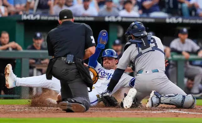 Kansas City Royals' Michael Massey, center, is tagged out at home by New York Yankees catcher Austin Wells as he tried to score on a single by Maikel Garcia during the third inning of baseball game Wednesday, May 27, 2026, in Kansas City, Mo. (AP Photo/Charlie Riedel)