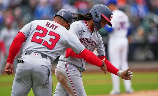 Washington Nationals' CJ Abrams, center, celebrates with first base coach Corey Ray, left, as he runs the bases after hitting a two run home run during the eighth inning of a baseball game Thursday, April 30, 2026, in New York. (AP Photo/Frank Franklin II)