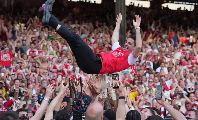 Arsenal's manager Mikel Arteta is thrown in the air by the players celebrating their Premier League title after the English Premier League soccer match between Crystal Palace and Arsenal in London, England, Sunday, May 24, 2026. (AP Photo/Kin Cheung)
