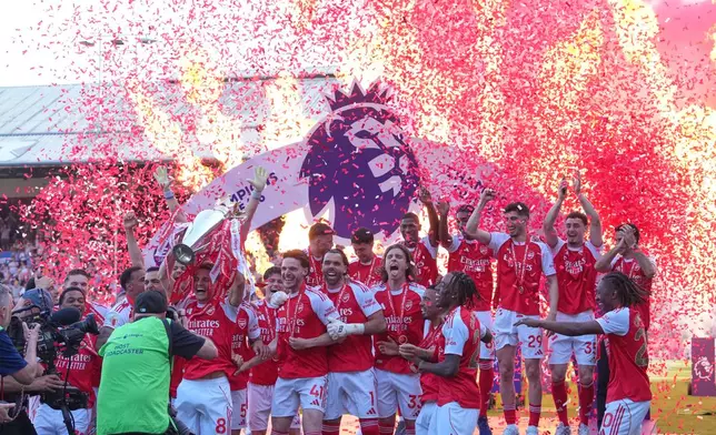 Arsenal players celebrate their Premier League title with the trophy after the English Premier League soccer match between Crystal Palace and Arsenal in London, England, Sunday, May 24, 2026. (AP Photo/Kin Cheung)