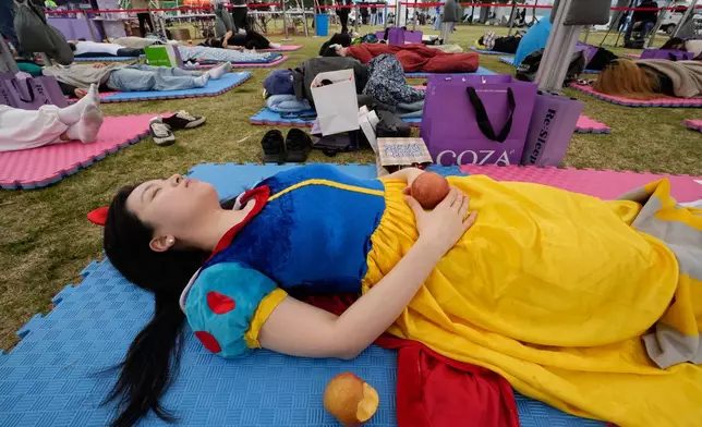 A participant dressed as Snow White takes a nap during the 2026 Hangang Nap Competition at Yeouido Hangang Park in Seoul, South Korea, Saturday, May 2, 2026. (AP Photo/Ahn Young-joon)