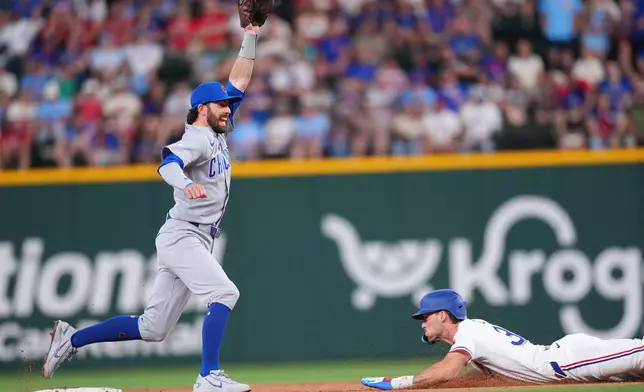Chicago Cubs shortstop Dansby Swanson, left, reaches for the throw from catcher Carson Kelly as Texas Rangers' Evan Carter, right, steals second base during the second inning of a baseball game Saturday, May 9, 2026, in Arlington, Texas. (AP Photo/Julio Cortez)