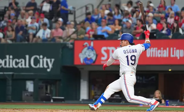 Texas Rangers' Alejandro Osuna follows through on a swing as he hits an RBI single to score Joc Pederson during the fourth inning of a baseball game against the Chicago Cubs, Saturday, May 9, 2026, in Arlington, Texas. (AP Photo/Julio Cortez)
