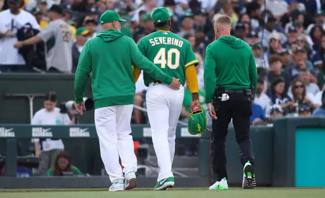 Athletics pitcher Luis Severino (40) walks off the mound with the trainer and manger Mark Kotsay, left, before the second inning of a baseball game against the New York Yankees Friday, May 29, 2026, in West Sacramento, Calif. (AP Photo/Scott Marshall)