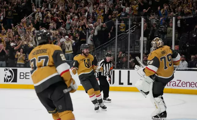 Vegas Golden Knights defenseman Shea Theodore (27), defenseman Rasmus Andersson (4) and goaltender Carter Hart (79) celebrate after winning Game 4 of the Western Conference finals NHL hockey Stanley Cup playoff series against the Colorado Avalanche Tuesday, May 26, 2026, in Las Vegas. (AP Photo/John Locher)