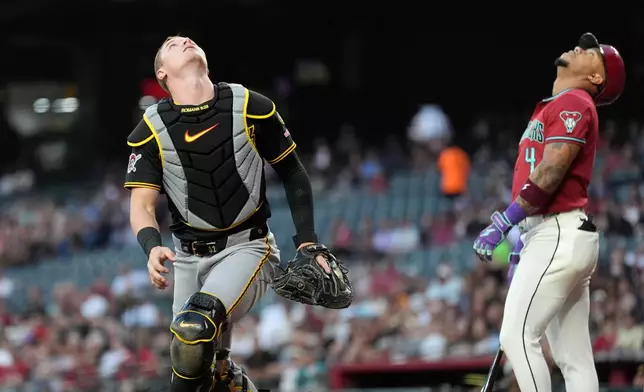 Pittsburgh Pirates catcher Henry Davis, left, looks for a foul ball hit by Arizona Diamondbacks' Ketel Marte (4) during the first inning of a baseball game, Wednesday, May 6, 2026, in Phoenix. (AP Photo/Ross D. Franklin)