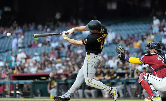 Pittsburgh Pirates' Bryan Reynolds, left, connects for a single as Arizona Diamondbacks catcher Gabriel Moreno reaches for the ball during the first inning of a baseball game, Wednesday, May 6, 2026, in Phoenix. (AP Photo/Ross D. Franklin)