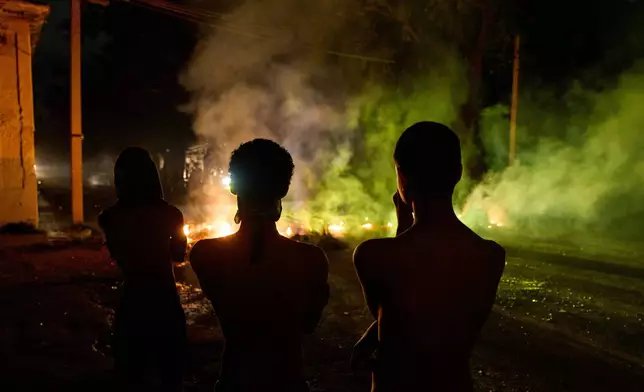 FILE - People look at a barricade set up by residents protesting against prolonged power outages in Havana, Cuba, May 13, 2026. (AP Photo/Ramon Espinosa, File)