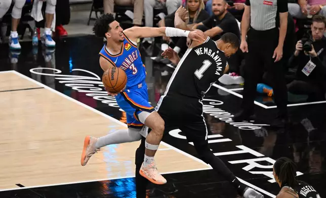 San Antonio Spurs forward Keldon Johnson (3) works toward the basket as San Antonio Spurs forward Victor Wembanyama (1) defends during the second half of Game 3 in the Western Conference finals NBA basketball playoffs series Friday, May 22, 2026, in San Antonio. (AP Photo/Darren Abate)