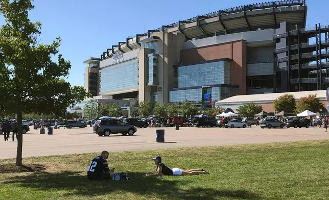 FILE - Fans spend time tailgating in the parking lot of Gillette Stadium before an NFL football game between the New England Patriots and the New York Jets, Sunday, Sept. 22, 2019, in Foxborough, Mass. (AP Photo/Bill Sikes, File)